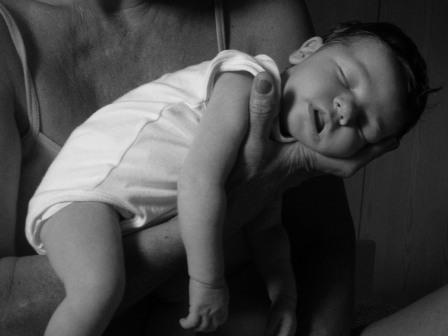 baby slaapt op arm
