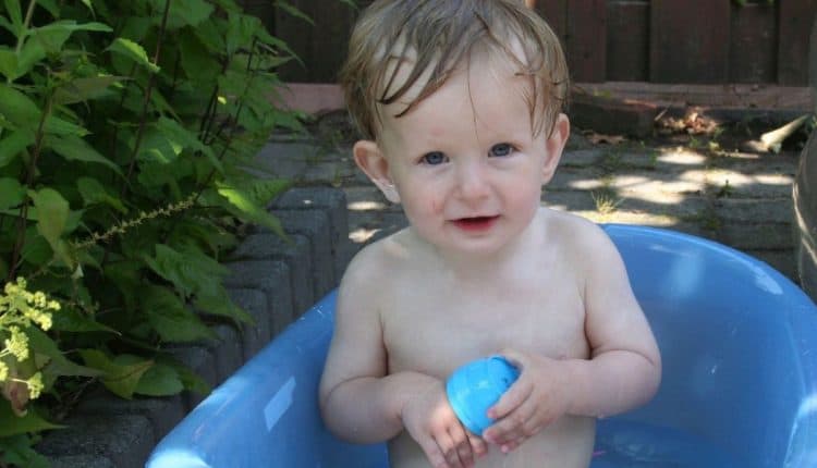Baby in badje bij warm weer in de tuin